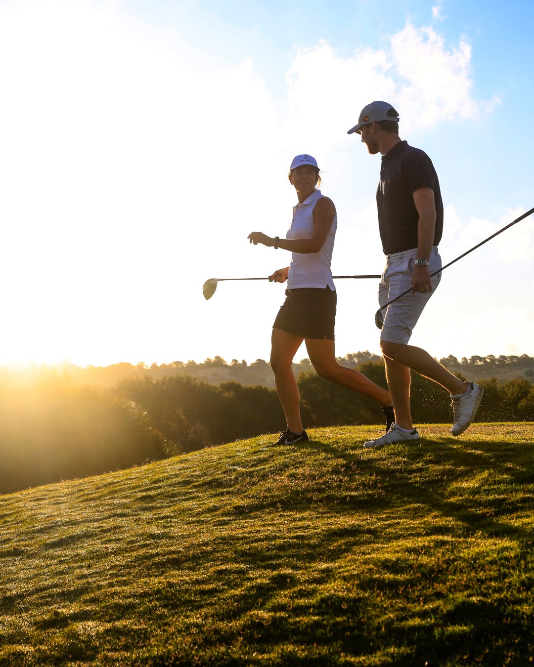 Happy couple playong golf in the setting Spanish sun